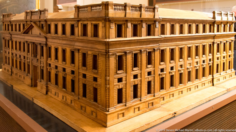 Wooden architectural model of a massive rectangular palace with repetitive windows, pilasters, and roof balustrade.