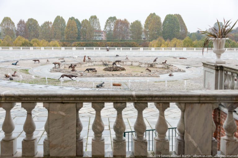 Elevated view of Velasco Vitali’s 2019 Branco installation, with many dog sculptures around the Fountain of the Stag in La Venaria Reale’s Court of Honor.