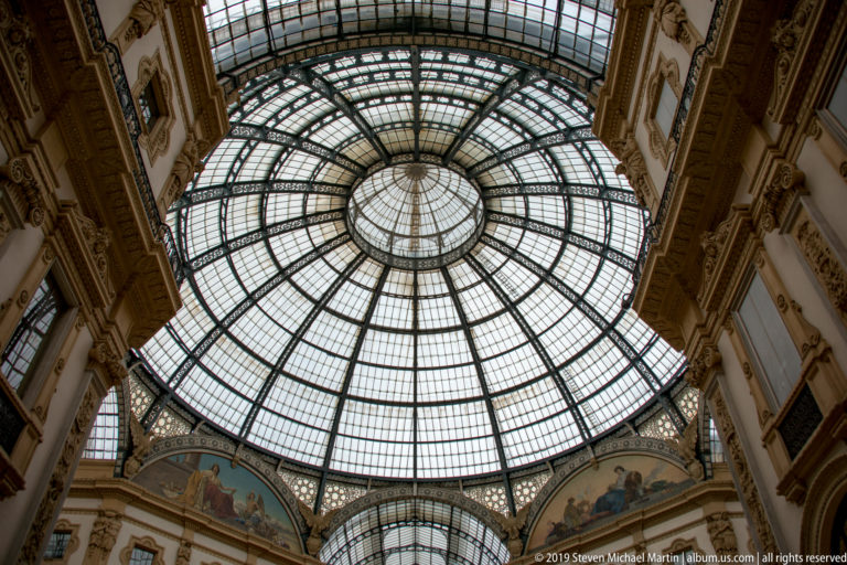 Upward view of the sweeping glass-and-iron roof inside the Galleria Vittorio Emanuele II.