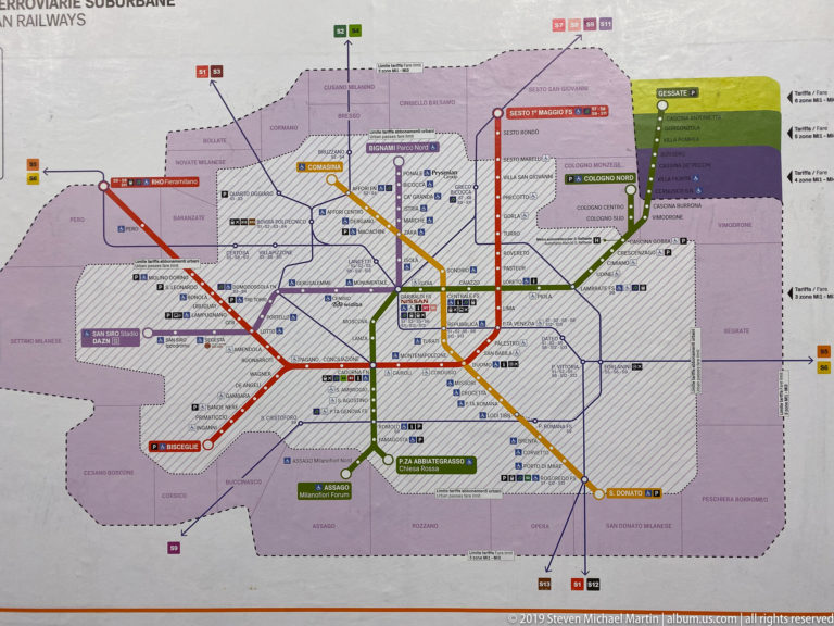 Color-coded schematic map of Milan rail and metro lines with stations and interchange points.