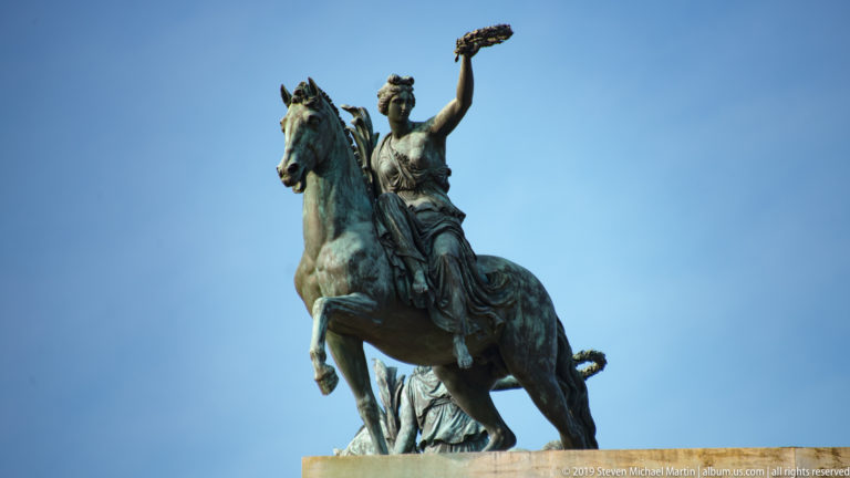 Bronze female figure on a rearing horse raising a wreath atop Milan’s Arco della Pace.