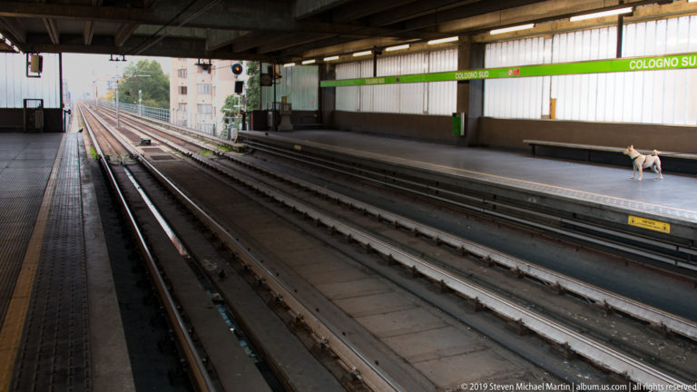 Tracks and platforms at Cologno Sud station on Milan Metro Line 2, with the green station sign visible.