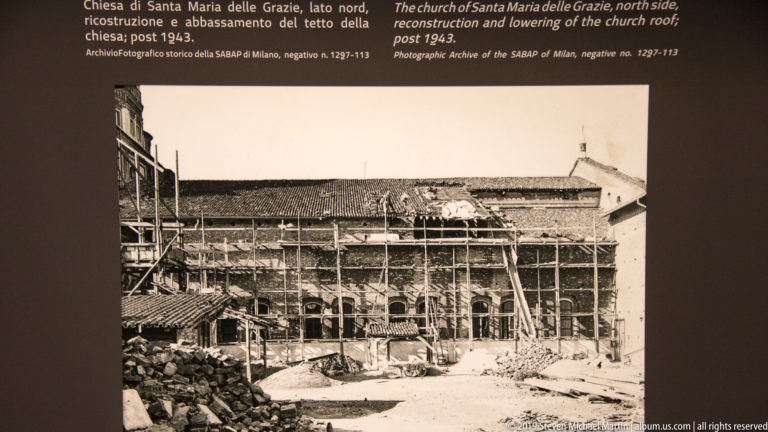 Postwar reconstruction scene with extensive scaffolding, workers, ladders, and rubble along a damaged wall of Santa Maria delle Grazie.