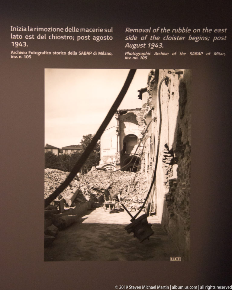 Workers clearing piles of rubble beside damaged cloister walls and surviving arches after the 1943 bombing.