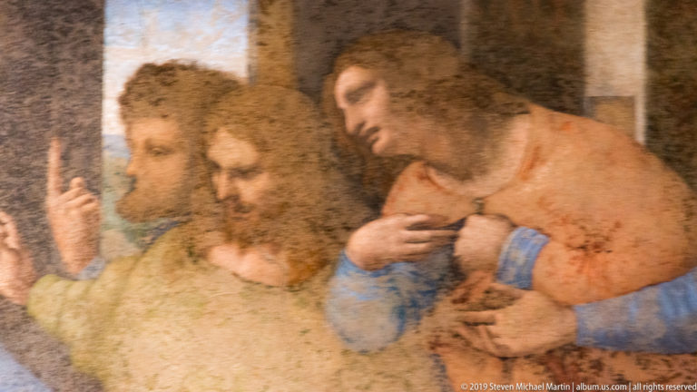 Thomas raises one finger behind James the Greater and Philip, who gesture beside Christ in The Last Supper.