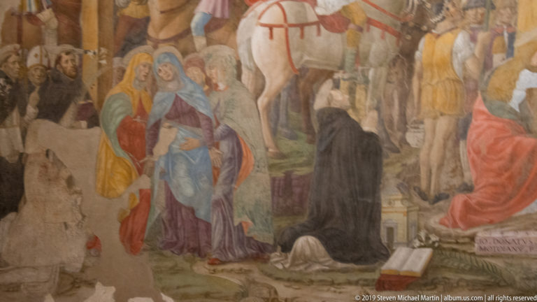 Women in blue, red, yellow, and purple beside black-habited figures, with a white horse and soldiers behind.
