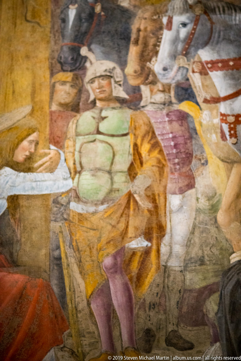 Detail of Montorfano’s Crucifixion showing soldiers in green, gold, and purple clothing beside the head and neck of a white horse.