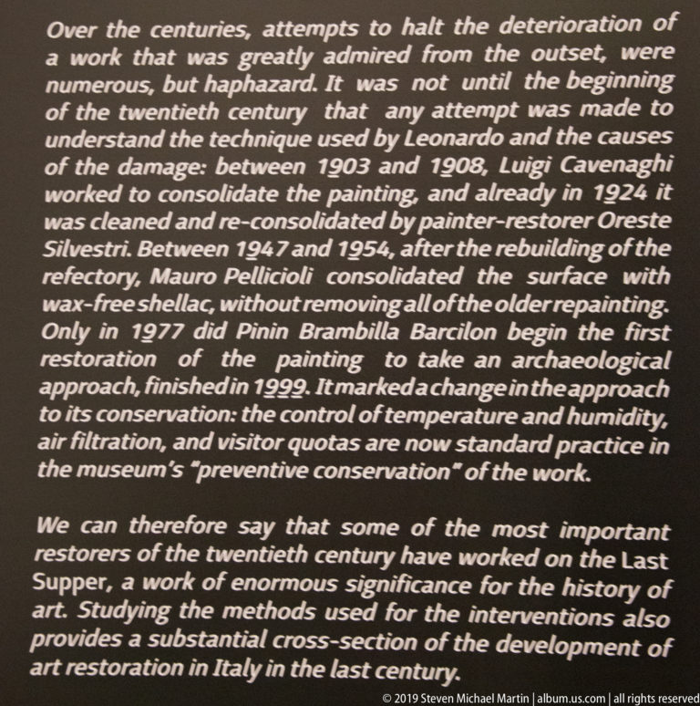 Close view of English museum text describing 20th-century restorations of The Last Supper and preventive conservation measures.