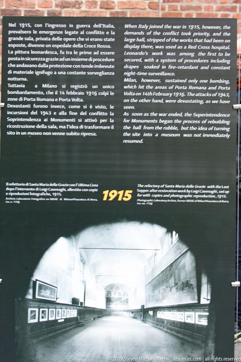 Interpretive panel dated 1915 with bilingual text and a historical photograph looking down the refectory toward The Last Supper.