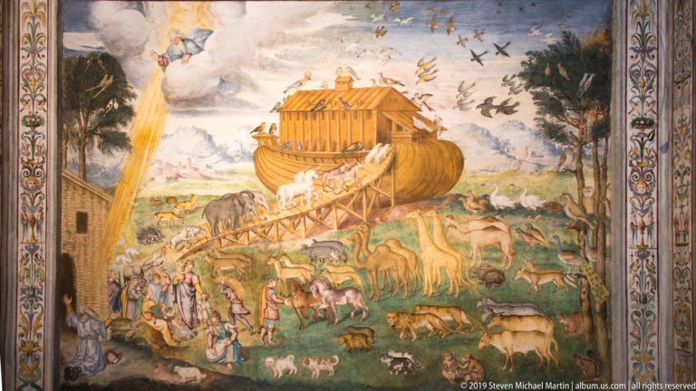 Fresco of Noah’s Ark with many animals moving up a ramp, people below, and birds flying across the sky.