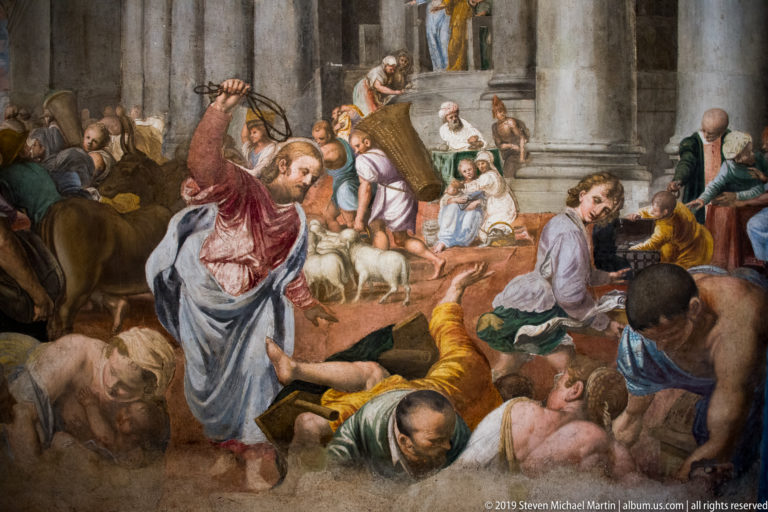 Crowded Renaissance fresco with a central robed figure bending toward people amid families, animals, and classical architecture.