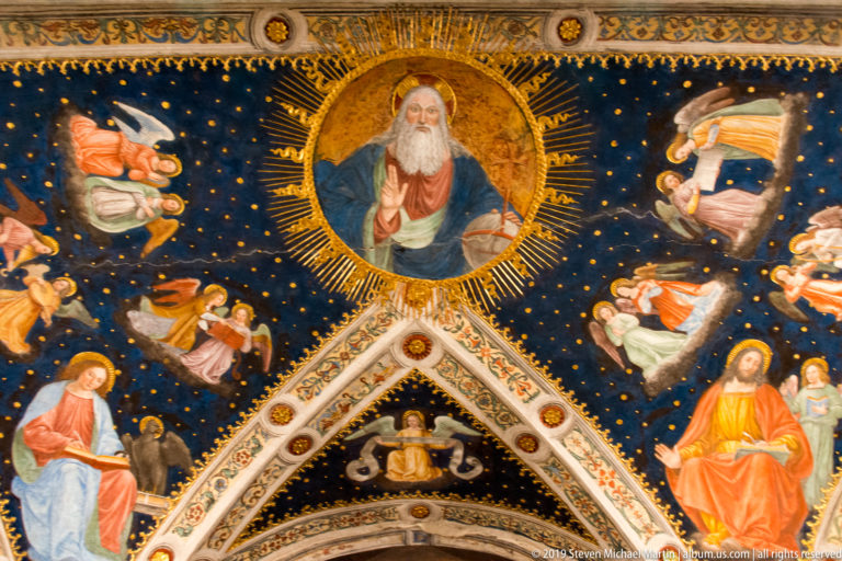 God the Father in a radiant circular medallion on a blue starry vault, surrounded by angels and sacred figures.