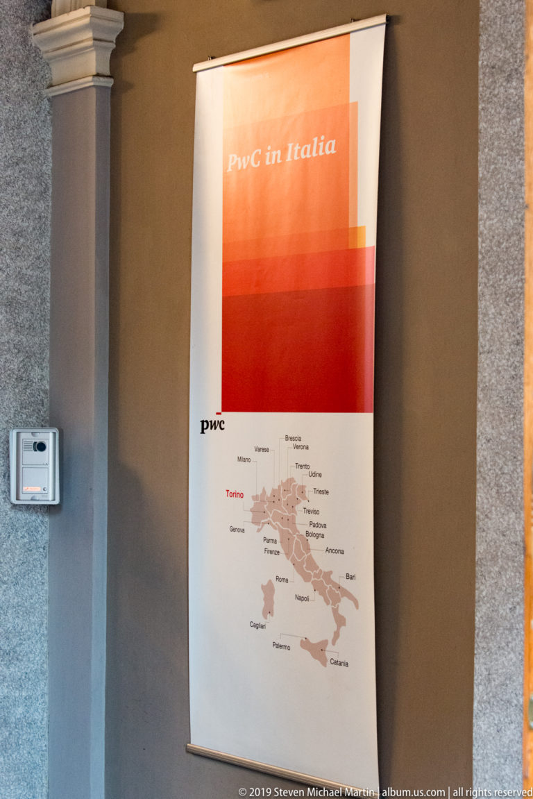 PwC in Italia banner on an office wall, showing a map of Italy with Torino and other office locations labeled.