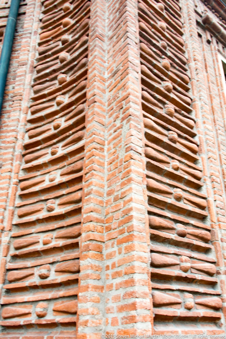 Close detail of Palazzo Carignano’s patterned red brickwork, with vertical pilasters crossing projecting horizontal courses.