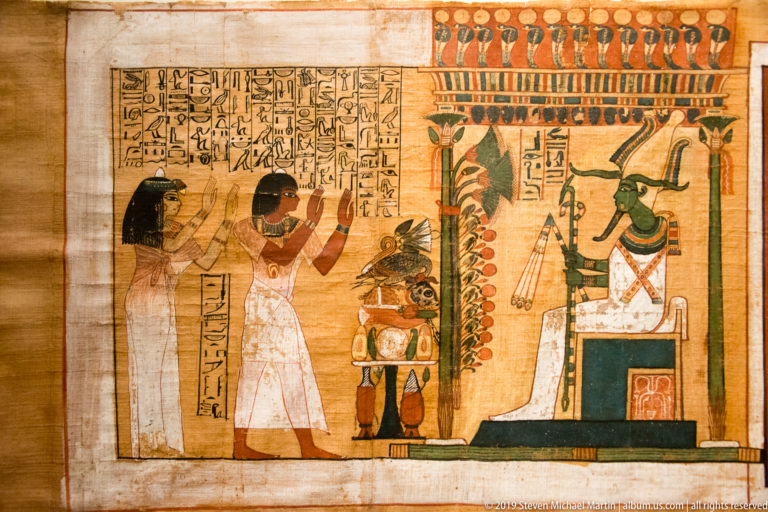 Painted papyrus vignette of Kha and Merit standing before the enthroned god Osiris beneath a decorated canopy.