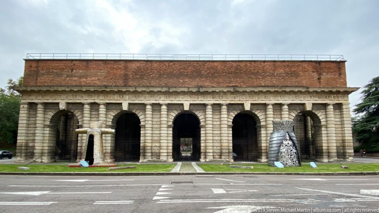 City side of Porta Palio with five tall rusticated arches beneath a broad entablature and red-tiled roof.