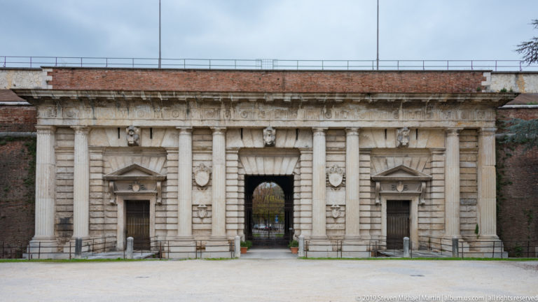 Porta Nuova façade with central arched passage, paired columns, rusticated masonry, side doors, pediments, and shields.