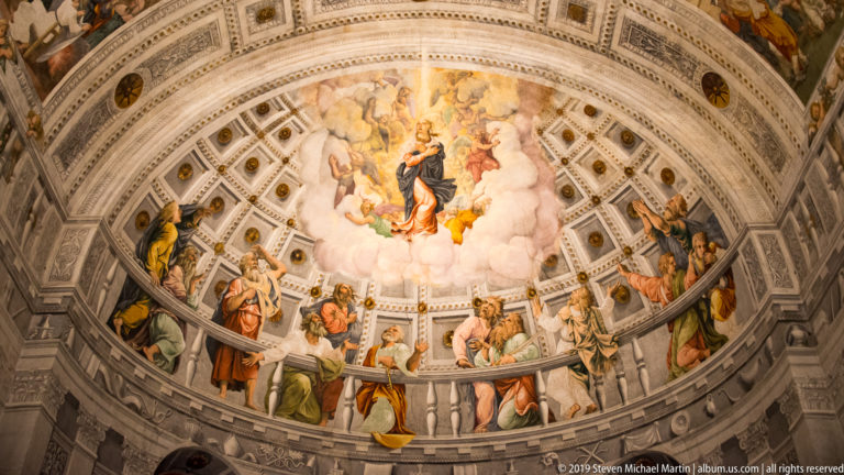 Symmetrical full view of the cathedral’s painted semi-dome, with a central heavenly scene above a ring of standing sacred figures.