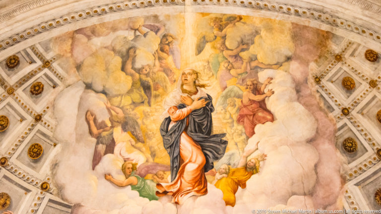 Close view of the central apse fresco, showing a robed sacred figure amid bright clouds and attendant figures.