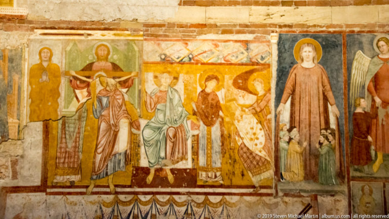 Colorful medieval fresco band with haloed standing saints and enthroned figures in adjacent panels.