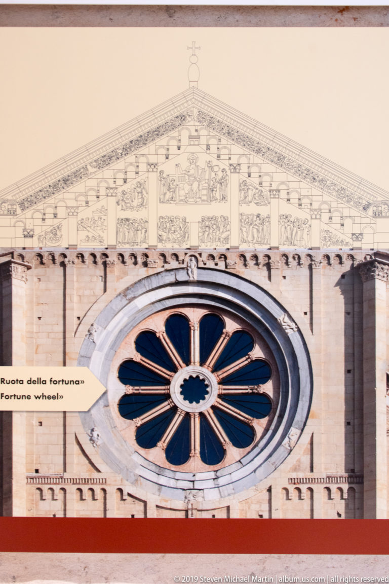 Interpretive panel showing San Zeno facade, rose window, and a line drawing of the upper gable sculpture.