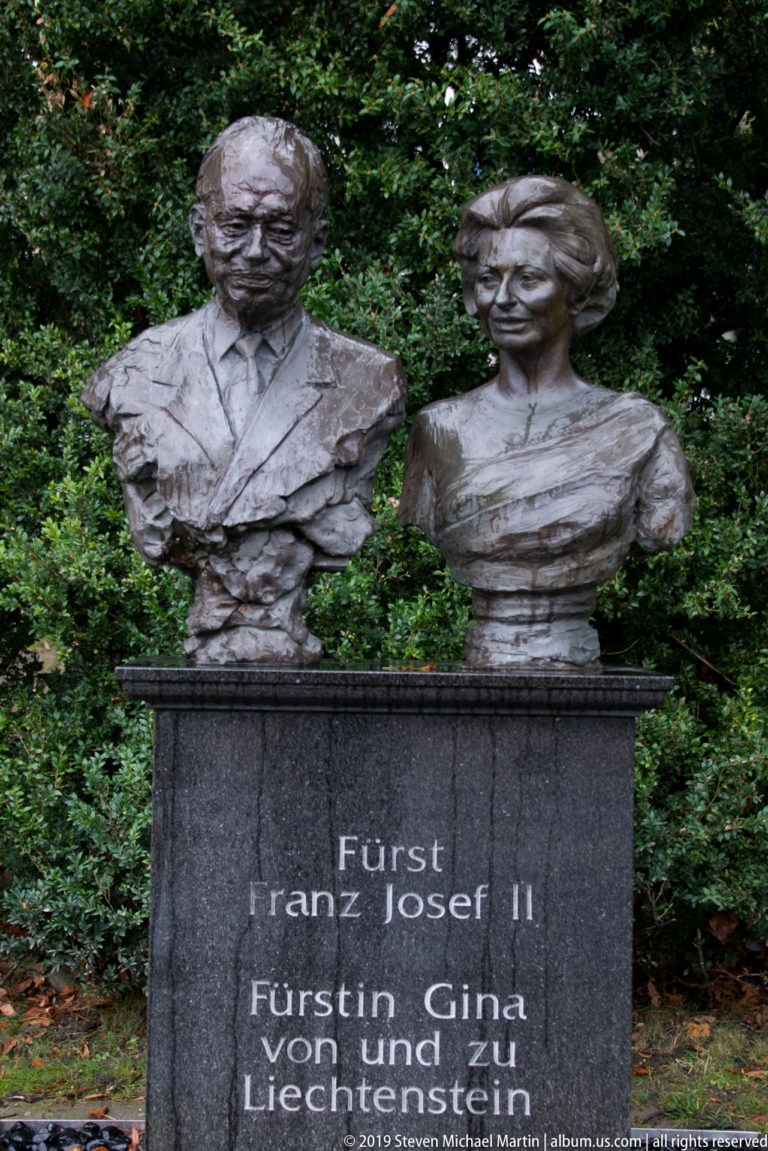 Bronze busts of Prince Franz Josef II and Princess Gina of Liechtenstein on an inscribed dark stone pedestal.