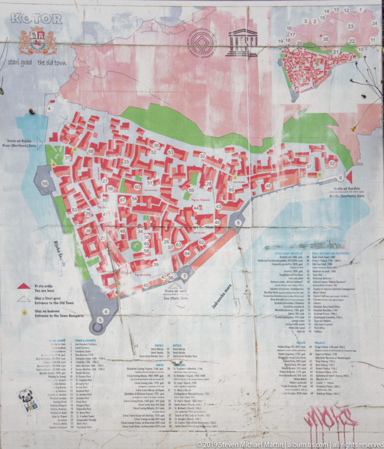 Illustrated visitor map of Kotor Old Town showing dense red building blocks, streets, waterfront, and a numbered legend.