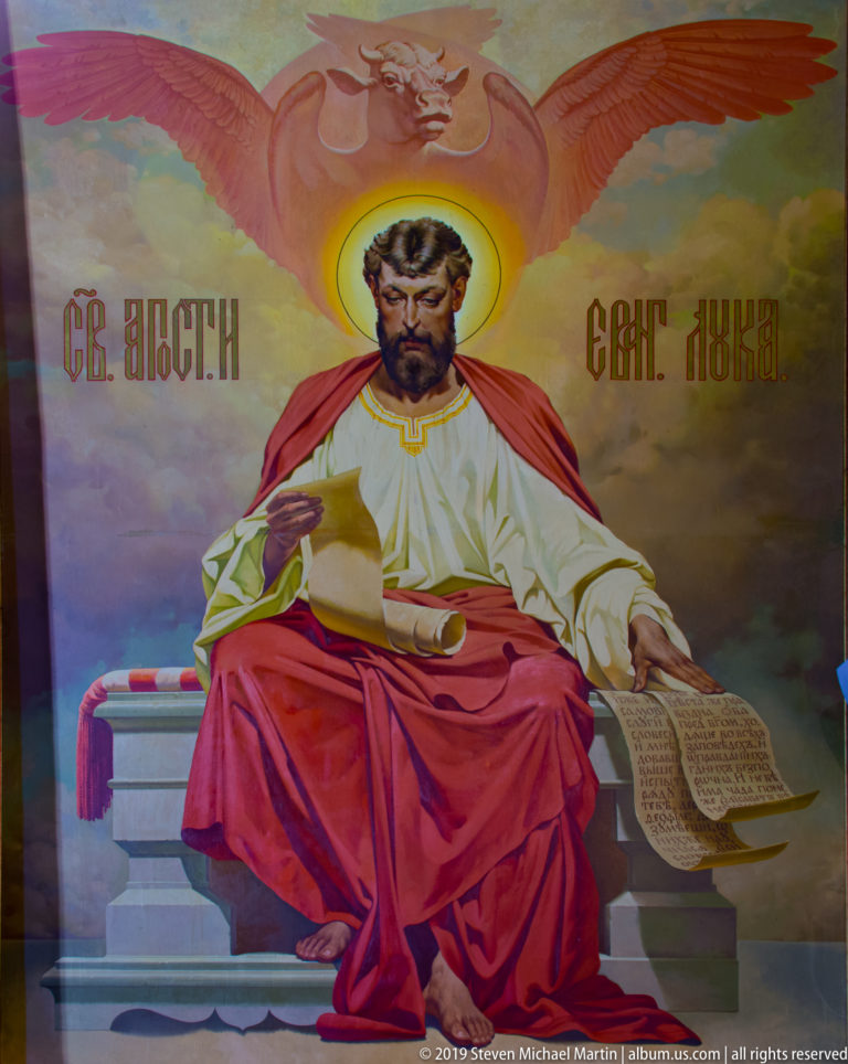Mural of St. Luke seated with a manuscript and a winged ox above, inside St. Nicholas Church in Kotor.