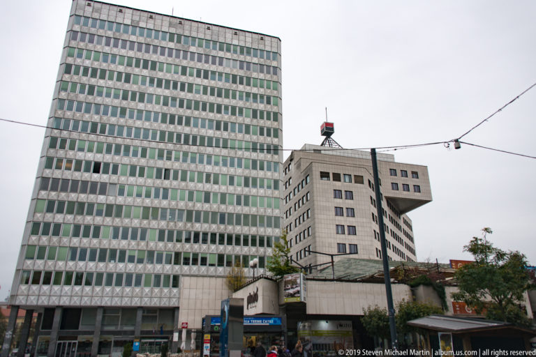 Modernist high-rise and angular office buildings with repetitive window grids in central Ljubljana.