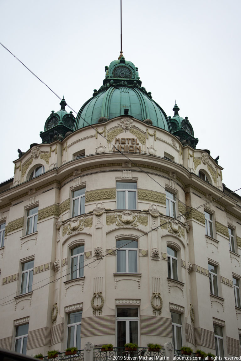 Grand Hotel Union with a curved ornate façade and green domed roof seen from below.