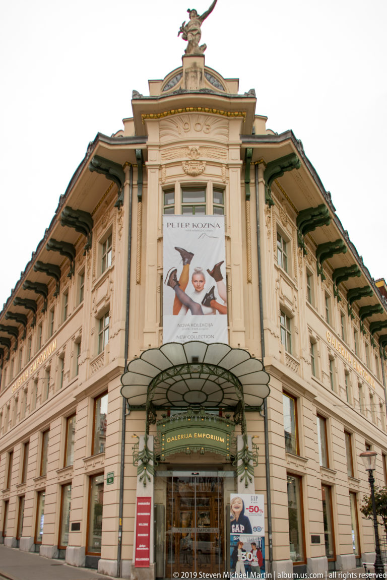 Galerija Emporium in an ornate historic corner building with sculptural decoration and a glass entrance canopy.