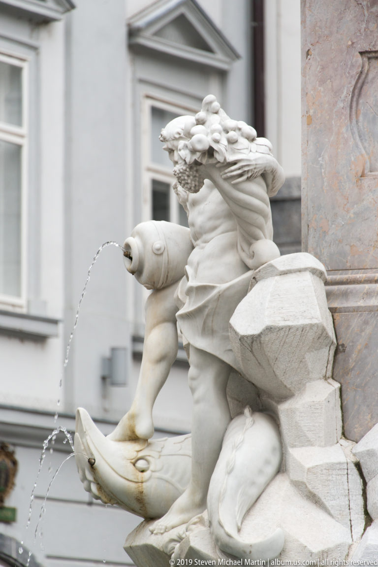 Stone river figure on the Robba Fountain pouring a thin stream of water from a vessel.