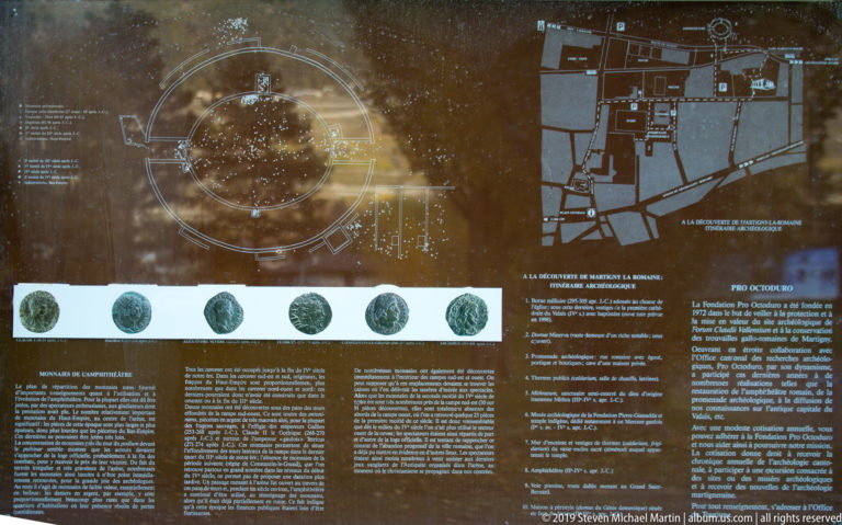 Brown information panel with amphitheatre plan, archaeological map, coin images, and blocks of multilingual text.