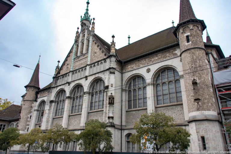Swiss National Museum façade with tall traceried windows, round corner turrets, steep roofs, and an ornate central gable.