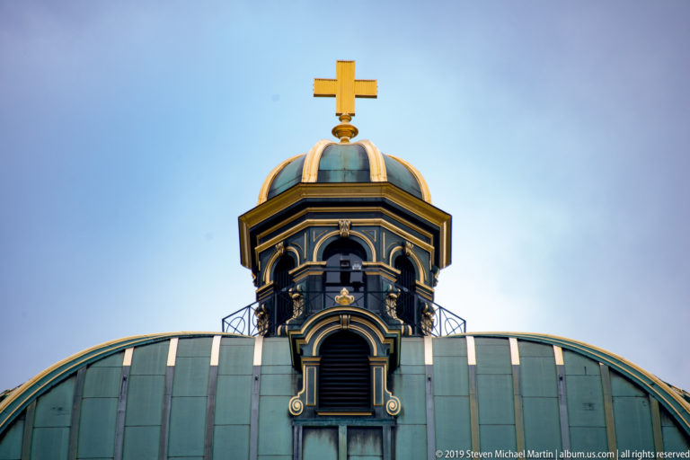 Close view of the Swiss Federal Palace dome and lantern topped by a gilded Swiss cross.