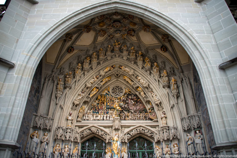 Gothic west portal of Bern Minster with sculpted archivolts, jamb figures, and the Last Judgment tympanum.