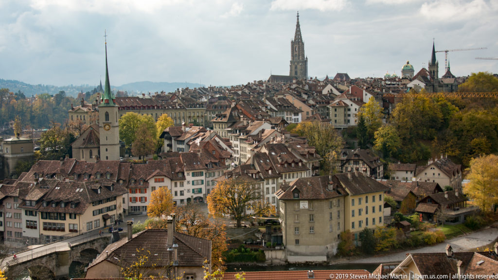 Bern Old City rooftops with the tall Gothic tower of Bern Minster dominating the skyline.