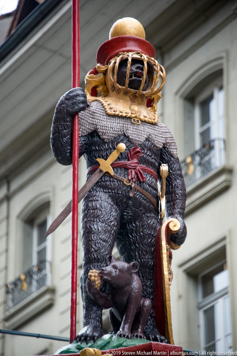 Close view of the armored bear and cub atop Bern’s Zähringerbrunnen fountain.