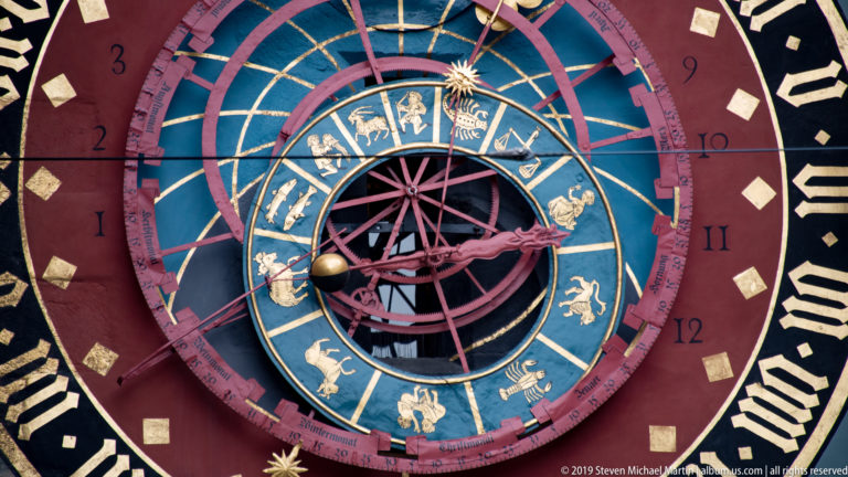 Close view of the Zytglogge astronomical clock’s zodiac ring, numbered fields, and central pointer mechanism.