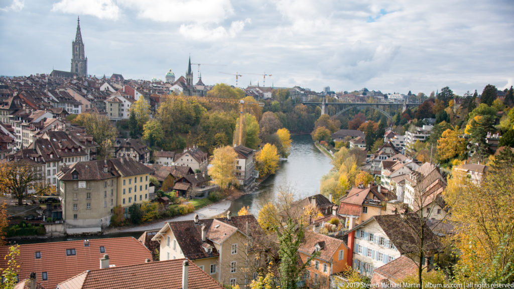 Aare River bend framed by autumn trees and hillside buildings below Bern’s Old City.