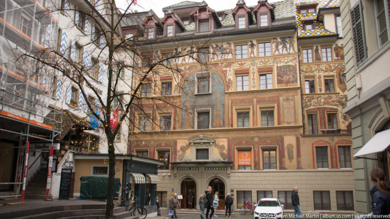 Ornately painted historic Lucerne building with figurative scenes, decorative borders, and rows of windows.