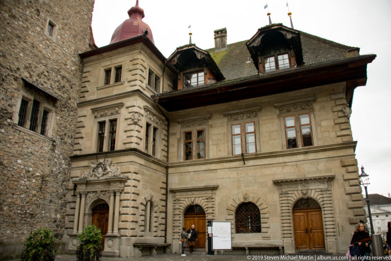 Historic Lucerne stone civic building with rusticated corners, carved portals, dormers, and tall windows.