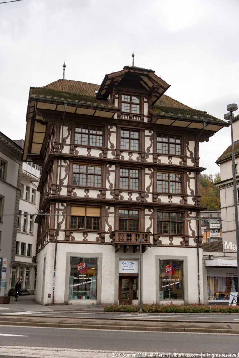 Large multi-story Lucerne building with exposed timber framing, rows of windows, and deep overhanging roof.