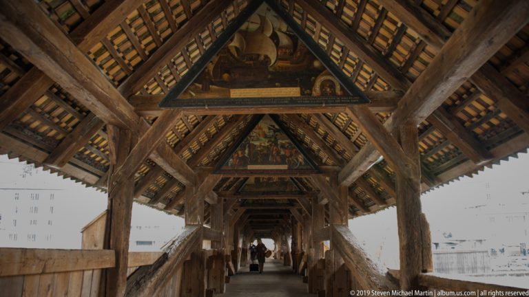 Covered Spreuer Bridge interior with painted triangular panels receding above the timber walkway.