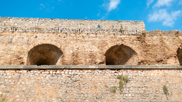 Two large brick-lined vaulted openings set into a thick stone wall at Palamidi Fortress.