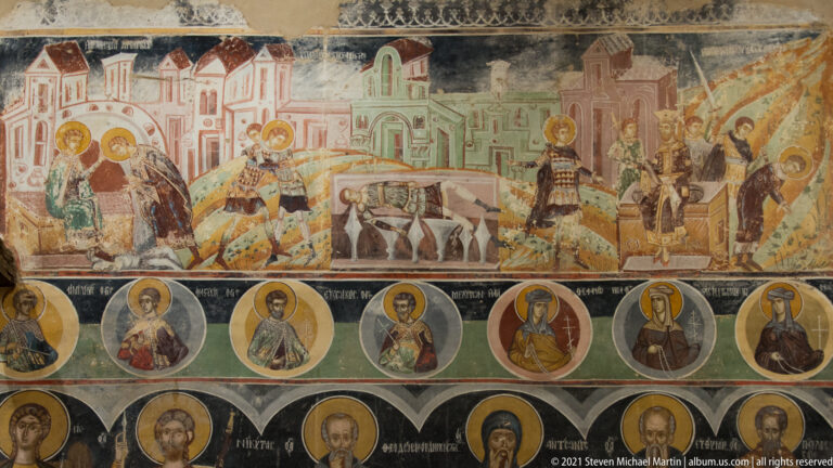 Multi-register fresco with an upper narrative scene and two lower rows of haloed saint portraits.