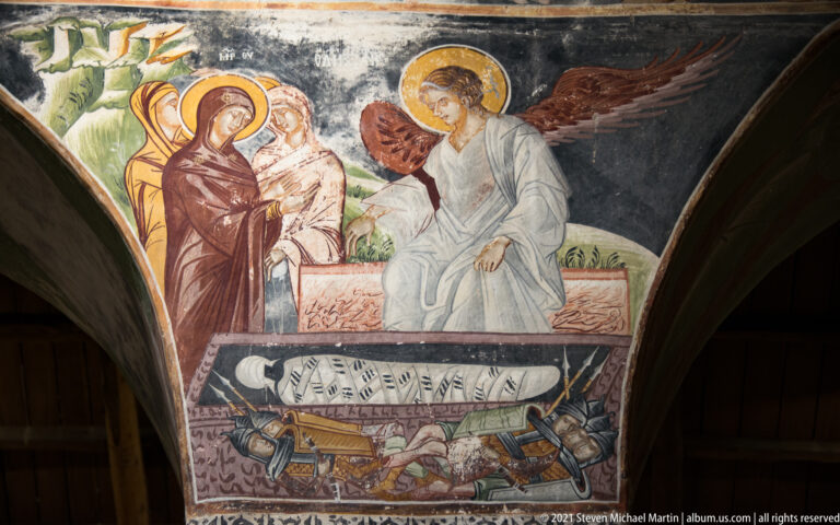 Nativity fresco with the reclining Virgin, swaddled Christ Child, and a winged angel above smaller figures.