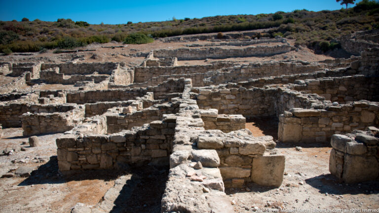 Oblique close view of thick intersecting stone walls and small excavated rooms at Ancient Kamiros.