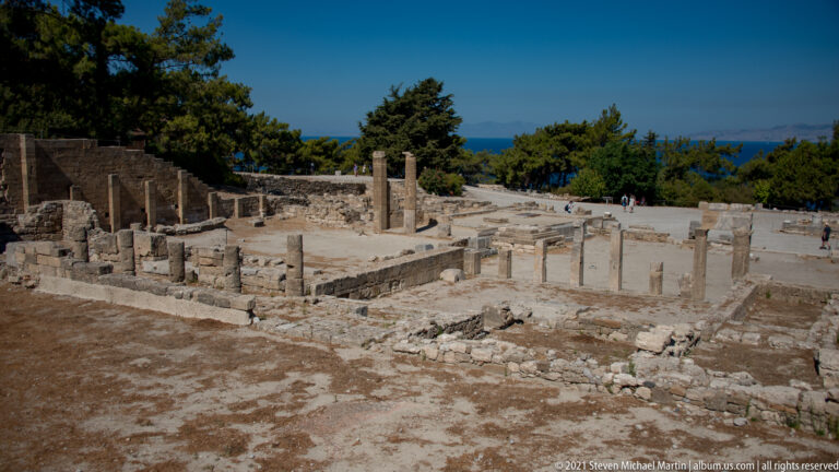Large open court with rows of standing columns, low foundations, and a stepped stone structure at Ancient Kamiros.