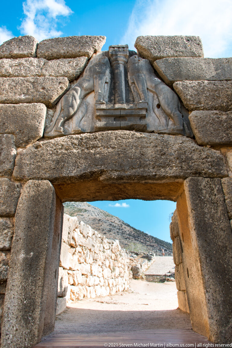 Low-angle close view of the Lion Gate lintel with the triangular lion relief directly above.